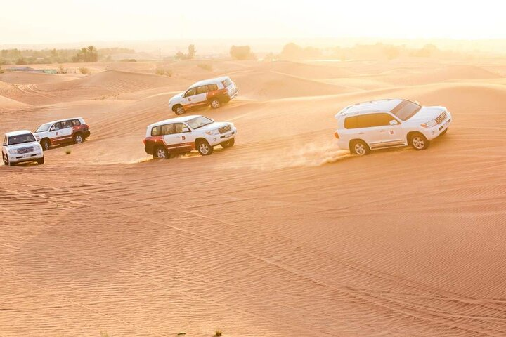 Experience exhilarating dune bashing across the stunning Arabian Desert where the golden sands create a dramatic backdrop for adventure and unforgettable memories under the vast sky.